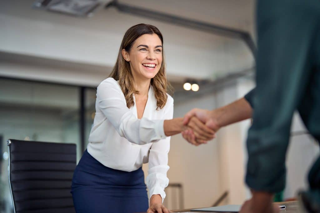 Woman in a meeting shaking someone's hand